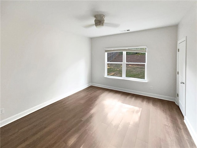 unfurnished bedroom with dark wood-style floors, a ceiling fan, visible vents, and baseboards