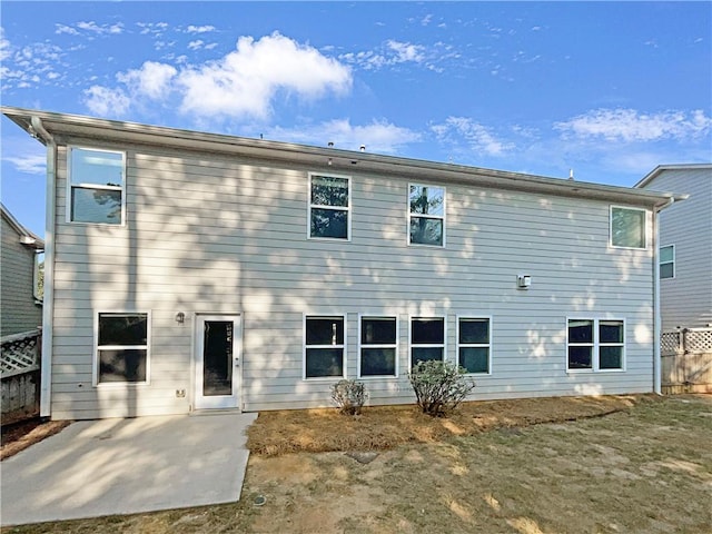 back of property featuring fence and a patio