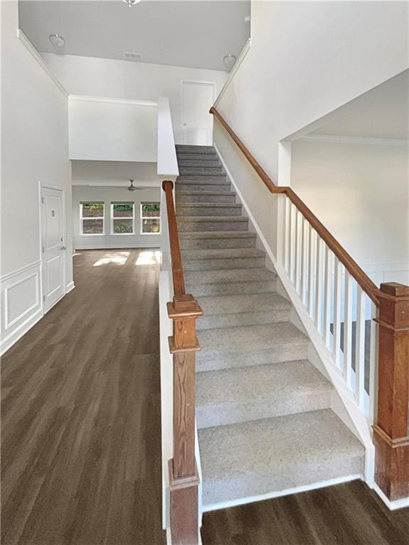 staircase featuring ornamental molding and wood finished floors