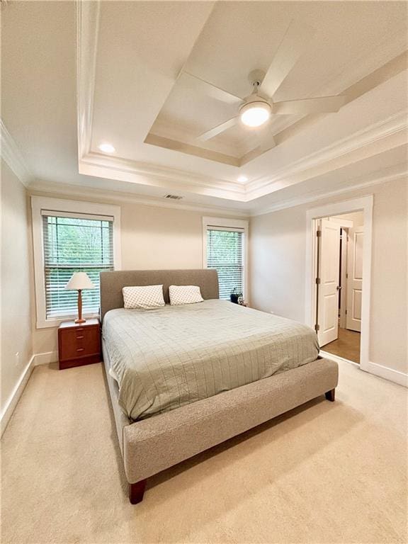 bedroom featuring ornamental molding, light carpet, a raised ceiling, multiple windows, and baseboards