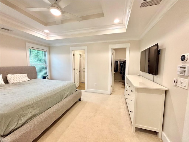 bedroom featuring crown molding, baseboards, a spacious closet, a raised ceiling, and light colored carpet