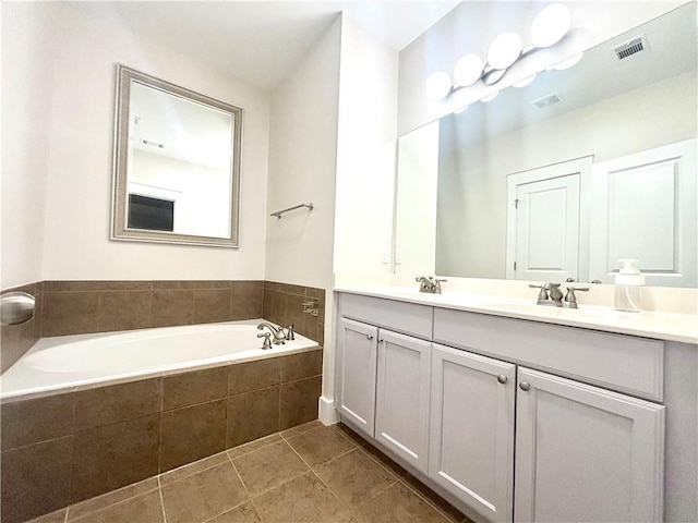 full bathroom with a bath, double vanity, and tile patterned floors