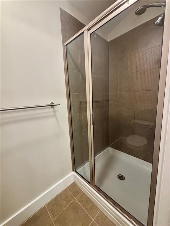 bathroom with tile patterned floors, a stall shower, and baseboards