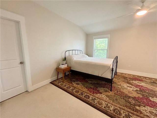carpeted bedroom with vaulted ceiling and baseboards
