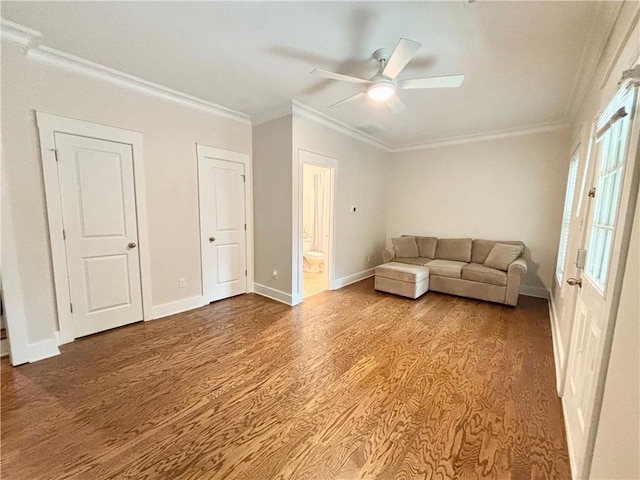 living area with wood finished floors, crown molding, ceiling fan, and baseboards