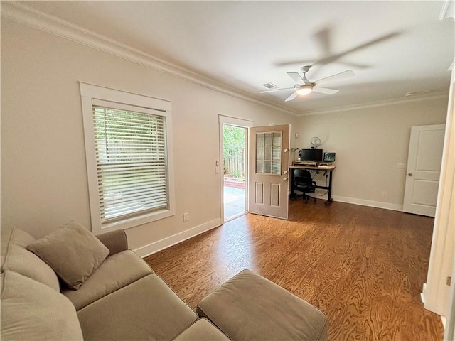 living area with a desk, ornamental molding, wood finished floors, baseboards, and a ceiling fan
