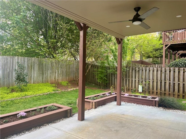 view of patio with a vegetable garden, ceiling fan, and a fenced backyard