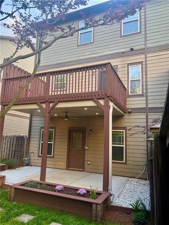 rear view of property featuring ceiling fan, fence, a balcony, and a patio area
