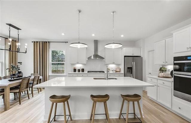108 NW Jane Blvd, Cartersville, GA 30120 - kitchen featuring wall chimney range hood, stainless steel appliances, a sink, a kitchen island with sink, and light countertops