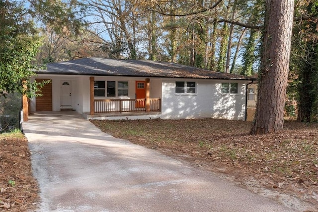 ranch-style home with covered porch and a carport