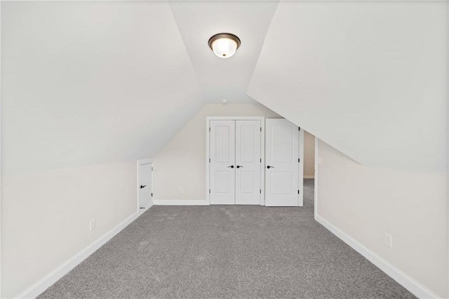 additional living space with carpet flooring and lofted ceiling