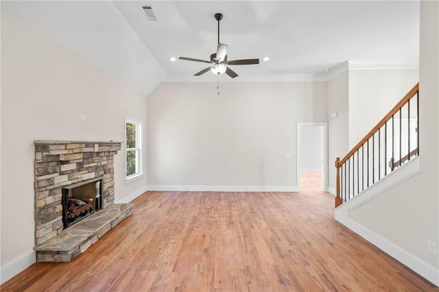 unfurnished living room featuring lofted ceiling, ceiling fan, ornamental molding, a fireplace, and light hardwood / wood-style floors