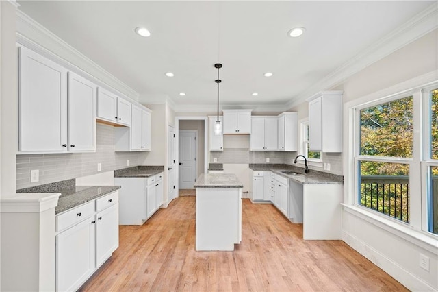 kitchen featuring white cabinetry, sink, plenty of natural light, and a kitchen island