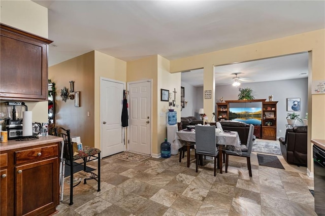 dining area with ceiling fan and stone finish floor