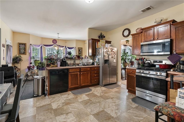 kitchen featuring visible vents, stainless steel appliances, plenty of natural light, and light countertops