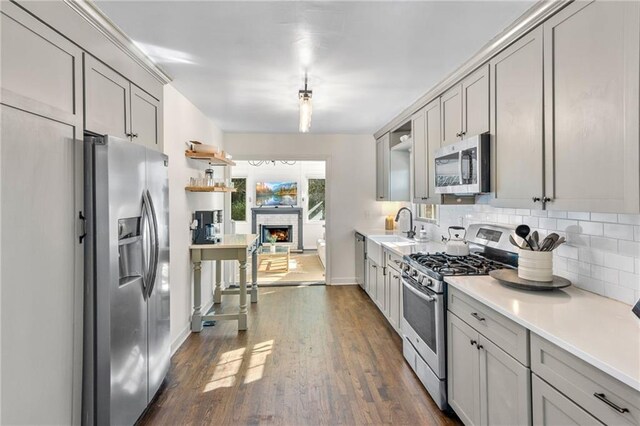 kitchen featuring dark hardwood / wood-style flooring, stainless steel appliances, and gray cabinetry