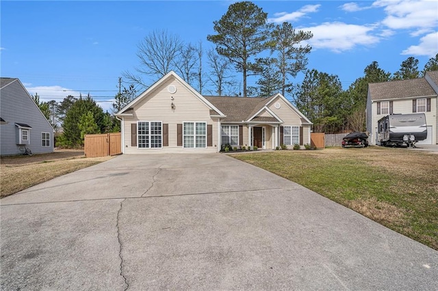 view of front of home featuring driveway, a front yard, and fence