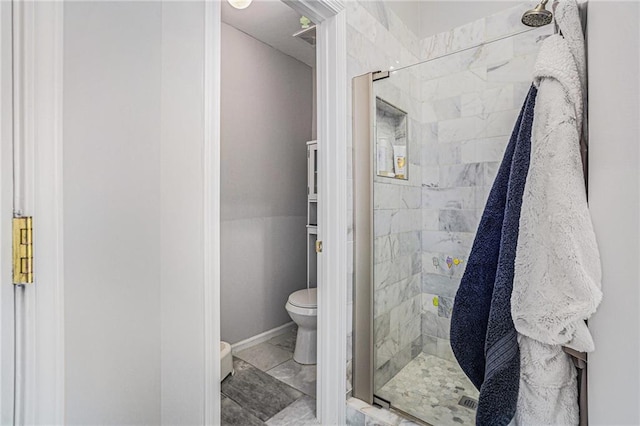 full bathroom featuring toilet, baseboards, and a stall shower