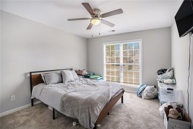 carpeted bedroom featuring a ceiling fan, visible vents, and baseboards