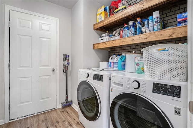 laundry room with laundry area, independent washer and dryer, and light wood-style flooring