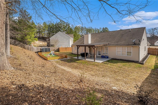 rear view of property with an outbuilding, a shed, a fenced backyard, a patio area, and a lawn