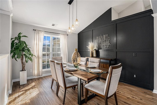 dining area with visible vents, baseboards, lofted ceiling, and light wood-style floors