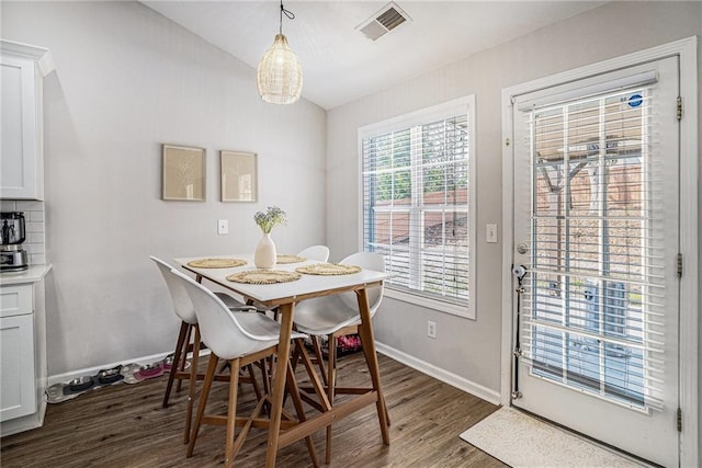 dining room with lofted ceiling, baseboards, visible vents, and dark wood-style flooring