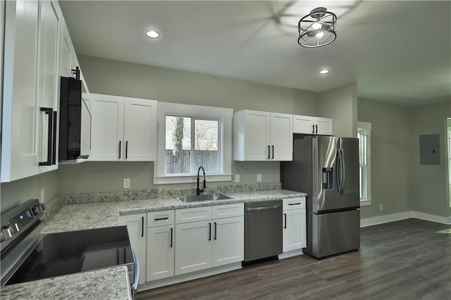 kitchen with stainless steel appliances, dark wood-style flooring, a sink, baseboards, and white cabinets