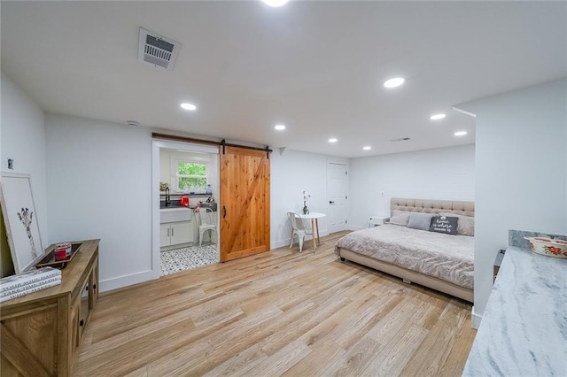 110 W Putnam Ferry Rd, Woodstock, GA 30189 - bedroom with a barn door, light wood finished floors, recessed lighting, baseboards, and ensuite bath
