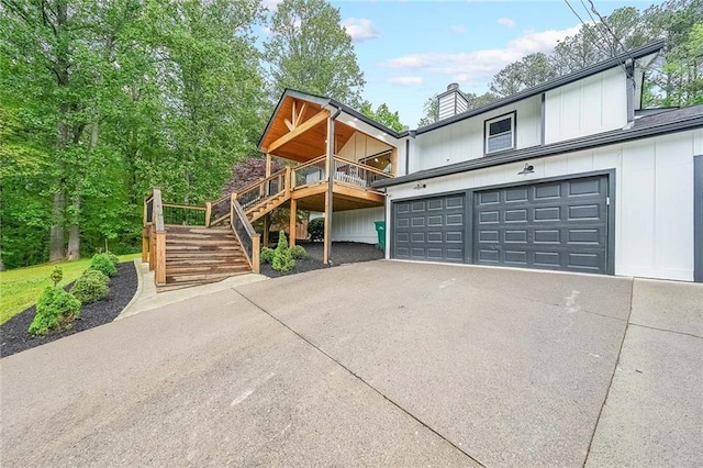 110 W Putnam Ferry Rd, Woodstock, GA 30189 - view of front of home featuring concrete driveway, stairs, a chimney, board and batten siding, and an attached garage