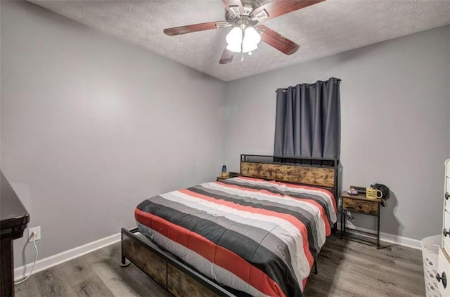 bedroom featuring ceiling fan, dark wood-type flooring, and a textured ceiling