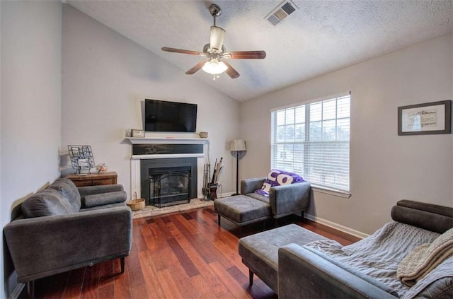 living room with ceiling fan, a textured ceiling, dark hardwood / wood-style flooring, and lofted ceiling