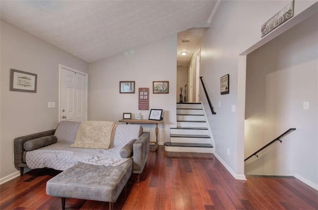 living area featuring dark wood-type flooring, a textured ceiling, and lofted ceiling