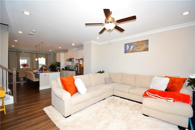 living room with crown molding, dark hardwood / wood-style flooring, and ceiling fan