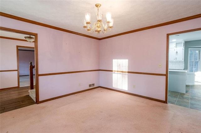 unfurnished room with crown molding, carpet flooring, and a chandelier