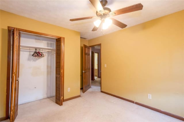 unfurnished bedroom with ceiling fan, light carpet, and a closet