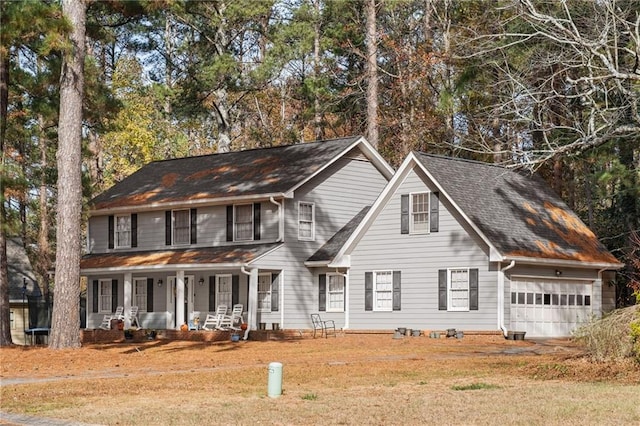 colonial house featuring a porch and a garage