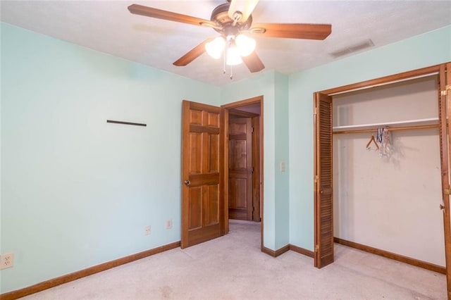 unfurnished bedroom featuring ceiling fan, light carpet, and a closet