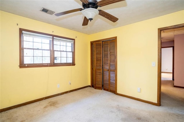 unfurnished bedroom featuring light carpet, a closet, and ceiling fan