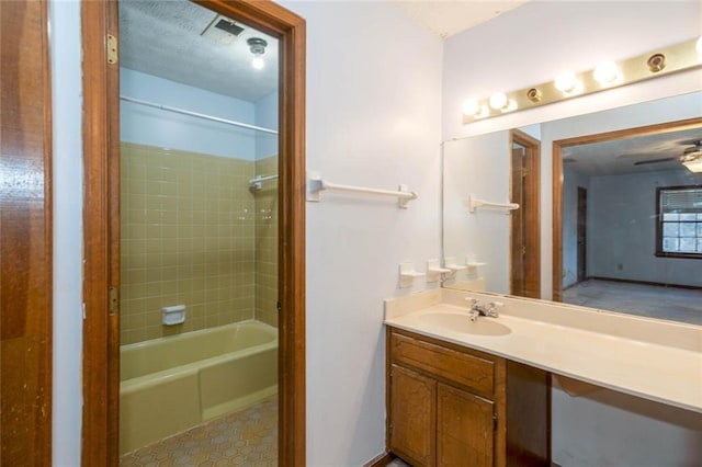 bathroom with tiled shower / bath and vanity