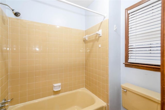 bathroom featuring tiled shower / bath combo and toilet