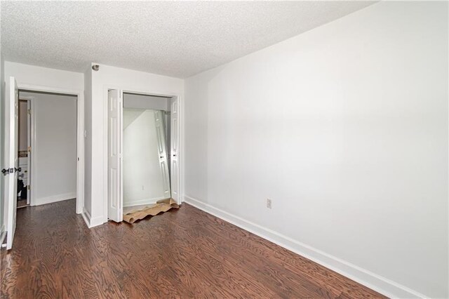 375 Ralph Mcgill Blvd NE Unit 807, Atlanta, GA 30312 - unfurnished bedroom featuring dark wood finished floors, baseboards, a closet, and a textured ceiling