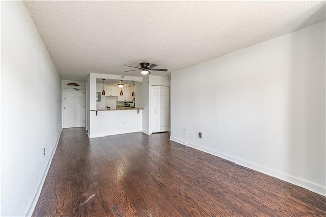 375 Ralph Mcgill Blvd NE Unit 807, Atlanta, GA 30312 - unfurnished living room featuring dark wood-style floors, baseboards, a textured ceiling, and a ceiling fan