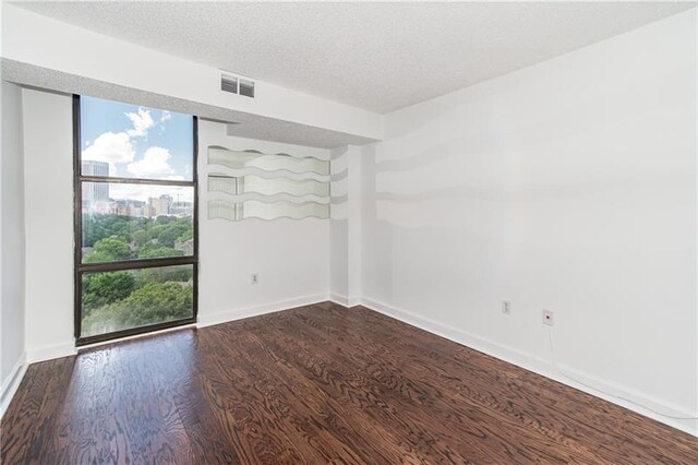 375 Ralph Mcgill Blvd NE Unit 807, Atlanta, GA 30312 - unfurnished room featuring visible vents, baseboards, a textured ceiling, and dark wood-style flooring