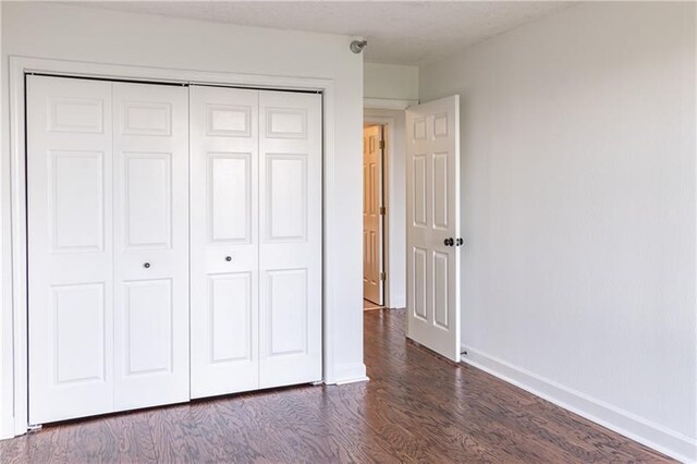 375 Ralph Mcgill Blvd NE Unit 807, Atlanta, GA 30312 - unfurnished bedroom with a closet, baseboards, and dark wood-type flooring