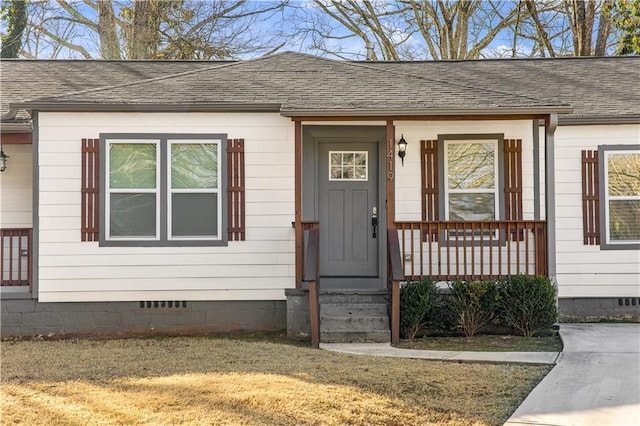 view of exterior entry with a yard