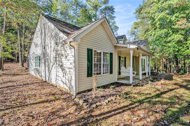 view of side of home featuring covered porch