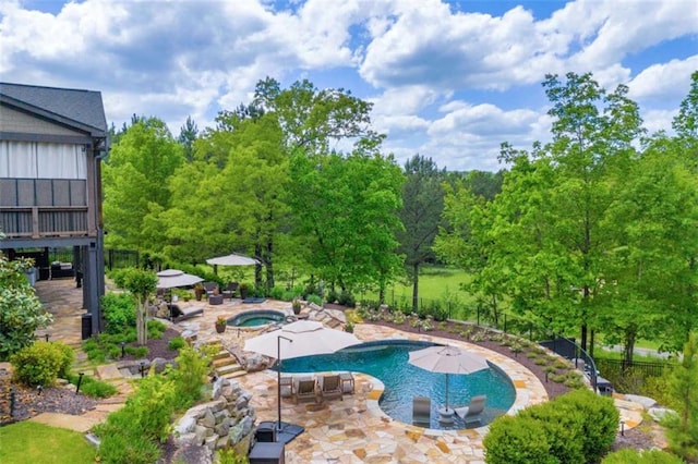 view of swimming pool featuring a patio area and an in ground hot tub