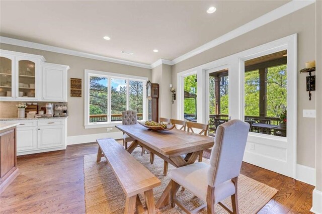 dining space featuring hardwood / wood-style floors and crown molding