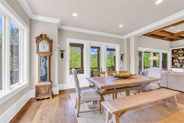 dining area with beam ceiling, plenty of natural light, coffered ceiling, and wood-type flooring